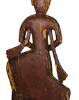 Wooden figurine of a seated figure with intricate carvings on a white background