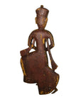 Wooden figurine of a seated figure with intricate carvings on a white background