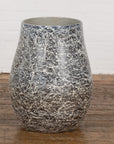 Black and white marble ceramic planter vase on wooden floor against a white brick wall.