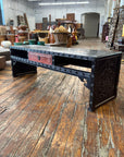 Black wooden bench with red drawer on worn floor next to antique black lacquer Chinese carved coffee table.