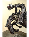 Bronze Frederic Remington "Rattlesnake" tabletop statue of cowboy on bucking horse, Western art style, on table.
