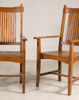 Brown teak Dutch Colonial dining armchairs with slat backs, pair shown side by side, vintage 1940s style.