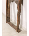 Angled view of lower side of carved architectural frame