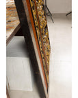 Giltwood Antique Chinese Qing wall panel with figural court scene leaning on a white bench over a light floor.