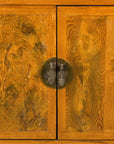Close-up of figured burlwood doors and round brass hardware