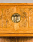 Close-up of upper burlwood doors with brass hinges and lock plate