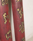 Close-up of lower gilt characters and worn red finish on Chinese wood panels