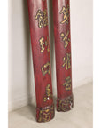 Close-up of the lower sections of red wood panels with gilt calligraphy and carved ends