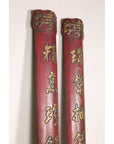 Close-up of the upper sections of red wood panels with raised gilt calligraphy