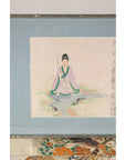 Close-up of the seated Japanese figure against a pale blue mat
