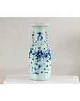 Close-up of blue and white porcelain vase with scenic designs and celadon glaze finish.