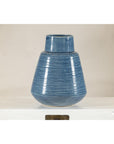 Blue-glazed ceramic vase with tapering form and horizontal ridges on a white surface.