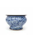 Blue and white ceramic bowl on a stack of books with a blurred bookshelf in the background