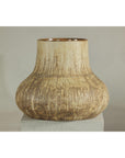 Cream and earth-toned textured ceramic vase on white pedestal, neutral background, close-up view.