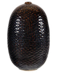 Close-up of deep brown and black ceramic vase with honeycomb texture, small opening, and sculptural oval shape.