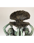 Bronze Greco Roman style three nymph fountain with women holding an open clam shell, white background.