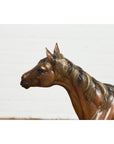 Bronze horse tabletop sculpture with detailed mane on black marble base, white background, close-up view.
