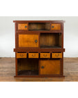Two-toned wood Japanese Taishō Mizuya Dansu kitchen cabinet with sliding doors on wooden floor against white wall.