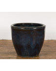 Blue and brown glazed ceramic Shigaraki style planter with wave patterns on a wooden floor, vintage oversized design.