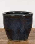 Blue and brown ceramic Shigaraki style Namako glazed planter with wave effects on a wooden floor.