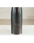 Charcoal ceramic vase with moss green glazed neck on a white surface, close-up.