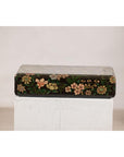 Black lacquer box with floral and bird designs, felt interior, displayed on a white pedestal against a plain background.