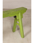 Green painted bench with A-frame supports, three-quarter end view