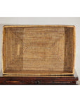 Woven rattan box on a wooden stand against a plain background