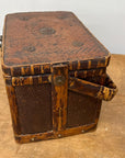 A Woven Rectangular Picnic Basket with Handle & Hinged Lid, featuring decorative metal accents and a rustic finish that showcases classic Southeast Asian craftsmanship, sits gracefully on a wooden surface.