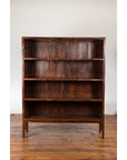 Dark wood Qing Dynasty bookcase with four shelves, 19th-century, placed against a white wall.