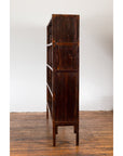 Side view of dark wood Chinese Qing Dynasty 19th century bookcase with four shelves, set against a white wall.