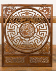 Brown wood Late Qing Dynasty fretwork panel with phoenix, bats, and maze pattern on woven table by white brick wall.