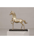 Close-up of a vintage silver over brass walking horse statuette on an ebonized oak base, plain background.