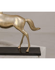 Close-up of vintage silver over brass walking horse statuette on ebonized oak base.