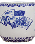 Close-up of blue and white porcelain planter with hand-painted landscape and decorative patterns on top and bottom edges.