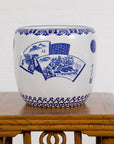 Blue and white porcelain planter with hand-painted landscape on carved wooden table, white background.