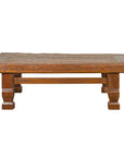 Brown primitive wood coffee table with distressed finish and block legs, rustic Indonesian style.