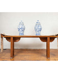 Brown wood Qing Dynasty altar table with bamboo accents, fretwork, and everted flanges, displayed with vases in bright room.