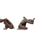 Bronze kneeling table bases with draped cloth and raised arms, vintage mid-20th century style, close-up.