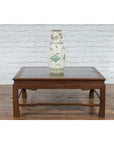 Decorative ceramic vase with floral and bird designs on a Burmese brown wood coffee table with lacquered top.