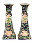 Close-up of pair of cobalt blue Chinese porcelain candlesticks with hand painted floral cartouches.