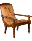 Brown leather Dutch Colonial plantation lounge chair, early 20th century, angled on plain white background.