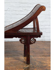 Side view of a brown elm and bamboo Chinese Qing Dynasty lounge chair with cloud carved spandrels on wooden floor.