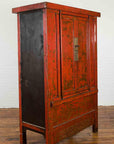 Red lacquered wood Chinese cabinet with ornate detailing, metal latch, and worn finish.