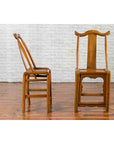 Brown wood Qing Dynasty yoke high back chairs, 19th century, side and front views on wood floor with white brick wall background.