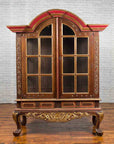 Gilded wood Dutch Colonial cabinet with bonnet top, glass doors, and ornate curved legs, early 20th century.