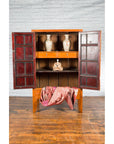 19th century elmwood armoire with medallion hardware and red-painted interior doors, Chinese Qing Dynasty style.