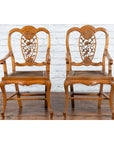 Brown wood Qing Dynasty 19th c. armchair with carved medallion on wood floor against a white brick wall.