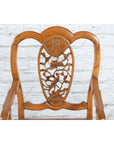 Dark wood 19th-century Qing Dynasty armchair with carved medallion, set against a white brick wall background.