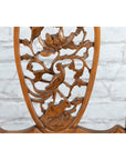 Close-up of a dark wood Chinese Qing Dynasty 19th-century armchair with carved medallion, white brick wall background.